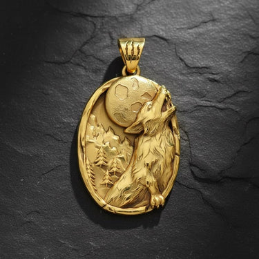 Gold vermeil howling wolf pendant with intricate relief carving of moon and forest scene on black background