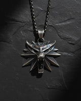 925 sterling silver wolf medallion pendant with spiked design held in hand showing detailed craftsmanship