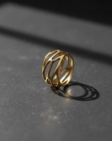 Gold vermeil parametric web ring with intricate openwork design on dark background