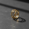Gold vermeil parametric web ring with intricate openwork design on dark background