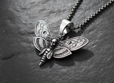 Silver Death Head Moth Pendant with an oxidized finish, showcasing detailed wing patterns on a dark slate background.