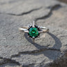 925 sterling silver starburst ring with emerald green stone and spike prongs on textured stone surface