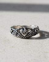 925 sterling silver claddagh skeleton hands ring with intricate bone detailing displayed on dark slate surface