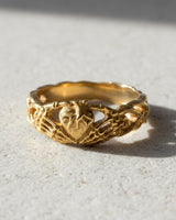 Close-up detail of handcrafted sterling silver skeleton hands ring showing oxidized finish and decorative band elements