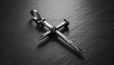 925 sterling silver nail cross pendant with oxidized finish and wire binding detail on dark wood surface