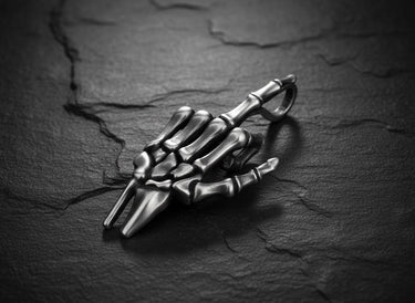 Side view of detailed bone structure pendant with polished sterling silver finish and keychain attachment