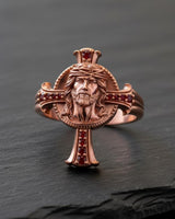 Rose gold Jesus cross ring with ruby accents displaying intricate religious craftsmanship and design