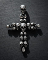 Gold vermeil skull cross pendant with multiple detailed skulls arranged in cross formation on dark slate