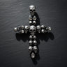 Gold vermeil skull cross pendant with multiple detailed skulls arranged in cross formation on dark slate