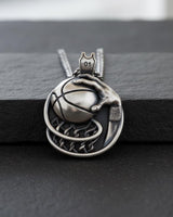 Close-up of polished sterling silver basketball pendant displaying intricate craftsmanship and chain attachment