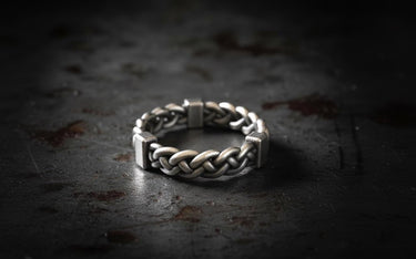 925 sterling silver twisted rope ring with chunky braided design and oxidized finish on dark textured background