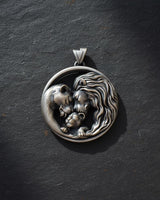 Detailed view of handcrafted lion family pendant with flowing manes and tender family bond in sterling silver