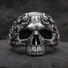 925 sterling silver baroque skull ring with ornate scrollwork displayed on dark textured stone surface