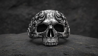 925 sterling silver baroque skull ring with ornate scrollwork displayed on dark textured stone surface