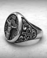 Side angle view of handcrafted religious signet ring showing ornate cross design and sterling silver band detail