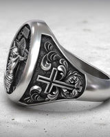 Close-up perspective of Catholic cross ring displaying crucifixion artwork and Latin text engraving craftsmanship