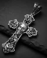 925 sterling silver Chicano cross pendant with skull and rose details displayed on dark surface with dramatic lighting