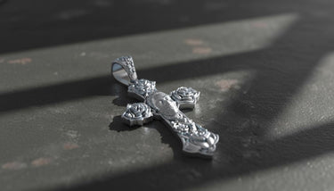 Gothic cross pendant showing intricate skull centerpiece and rose motifs at cross ends in oxidized sterling silver