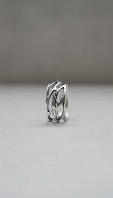 Close-up view of parametric silver ring displaying intricate openwork design and architectural geometric details