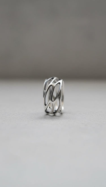 Close-up view of parametric silver ring displaying intricate openwork design and architectural geometric details