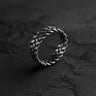 925 sterling silver Celtic knot ring with intricate braided pattern displayed on dark textured stone surface