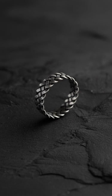925 sterling silver Celtic knot ring with intricate braided pattern displayed on dark textured stone surface