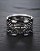 Close-up detail of silver dragon ring displaying carved dragon faces and premium metalwork craftsmanship