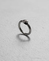 925 sterling silver ouroboros snake ring with detailed scales and oxidized finish displayed on white textured background