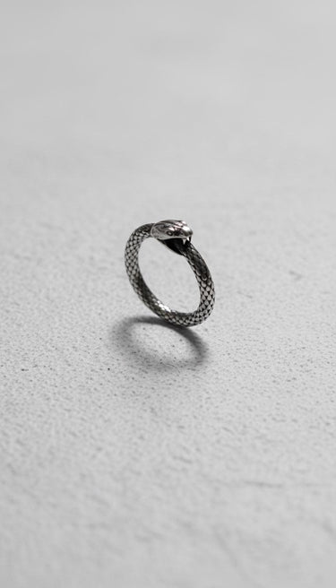 925 sterling silver ouroboros snake ring with detailed scales and oxidized finish displayed on white textured background