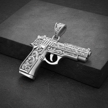 Side angle view of handcrafted gun pendant showing detailed scroll work and premium silver finish