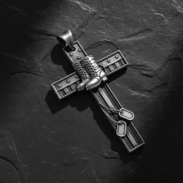 Gold vermeil military cross pendant with combat boots and dog tags on dark slate background showing patriotic design