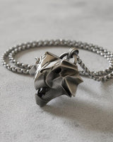 Side angle view of handcrafted griffin medallion showing dimensional depth and oxidized silver finish details