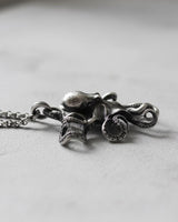 Side view of silver octopus pendant with chain showing three-dimensional craftsmanship and marine details