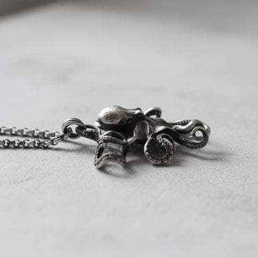 Side view of silver octopus pendant with chain showing three-dimensional craftsmanship and marine details