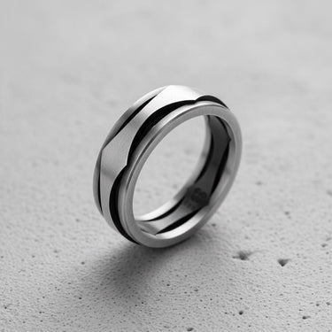 925 sterling silver wave ring with black accent lines displayed on textured concrete surface background