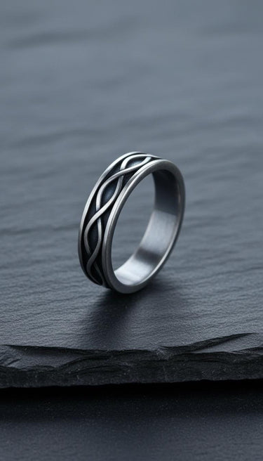 Sterling silver infinity ring photographed on dark wood surface highlighting the endless loop design pattern