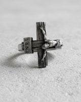 Close-up perspective of religious cross ring displaying intricate metalwork and INRI inscription on silver band
