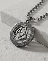 Side angle view of handcrafted triquetra pendant showing oxidized finish and dimensional Celtic symbol detail