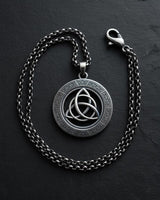 925 sterling silver triquetra pendant with Celtic knotwork border displayed on dark slate background with chain