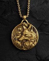 Gold-toned fox pendant necklace featuring wildlife design with chain on textured black stone surface