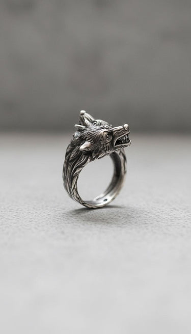 Side view of handcrafted sterling silver wolf ring showing dual wolf heads and polished band construction detail