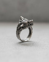 Side view of handcrafted wolf ring showing fierce wolf faces with bared fangs and oxidized silver finish