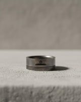 Side angle view of handcrafted sterling silver piston ring showing authentic engine channel details and band thickness