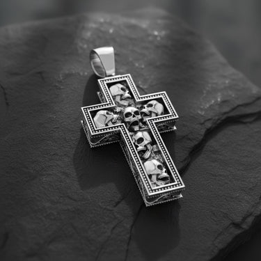 Gold version of skull cross pendant displaying dimensional craftsmanship and detailed metalwork on textured surface