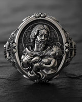 925 sterling silver Saint Joseph ring with baby Jesus in black rhodium finish displayed on dark wooden background