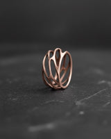 Rose gold plated silver parametric ring with organic openwork design on dark background