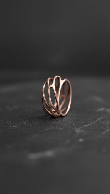 Rose gold plated silver parametric ring with organic openwork design on dark background