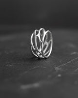 Front view of 925 sterling silver parametric ring with organic web design on dark background