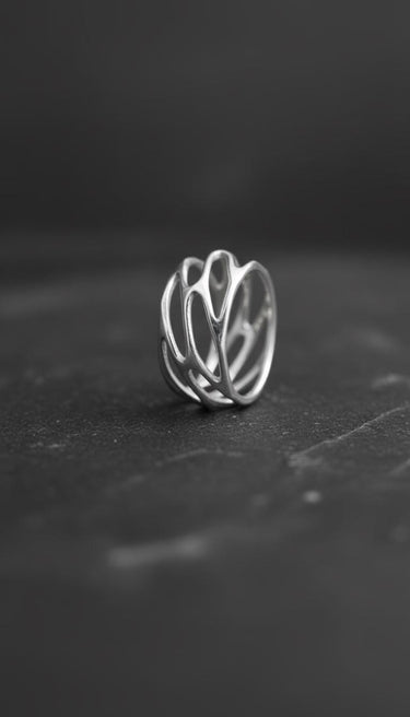 Front view of 925 sterling silver parametric ring with organic web design on dark background