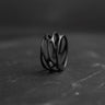 Black rhodium plated sterling silver parametric ring with organic web design displayed on dark stone surface